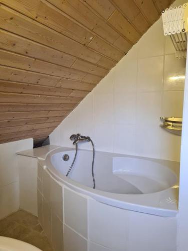 a bath tub in a bathroom with a wooden ceiling at Cozy Apartment in Wülfrath