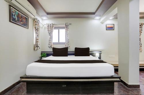 a bedroom with a large white bed and a window at Collection O Mandvi Bus Terminal Formerly Hotel Shraddha in Mandvi