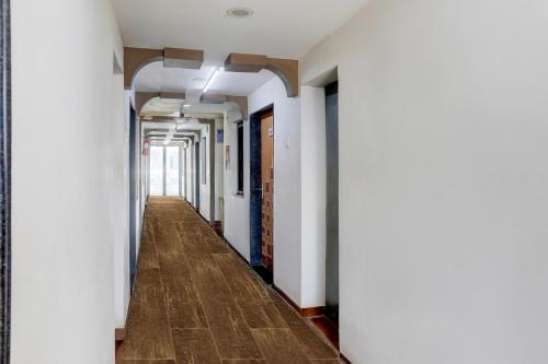 an empty hallway with white walls and a wooden floor at Collection O Mandvi Bus Terminal Formerly Hotel Shraddha in Mandvi