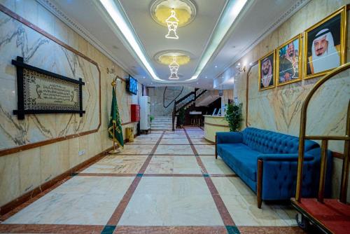 a hallway with a blue couch in a building at زهرة الميناء للشقق المخدومة in Jeddah