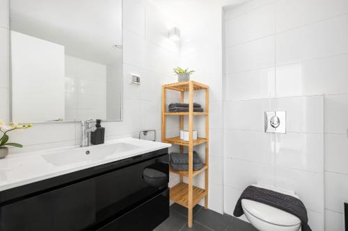 a bathroom with a sink and a toilet and a mirror at Boutique Duplex 3BR Florentin in Mashabbe Sade
