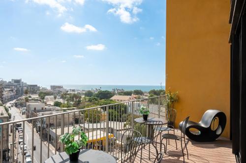 a balcony with tables and chairs and a view of a city at Boutique Duplex 3BR Florentin in Mashabbe Sade