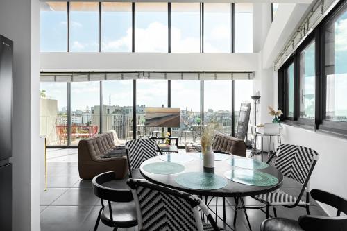 a living room with a table and chairs at Boutique Duplex 3BR Florentin in Mashabbe Sade