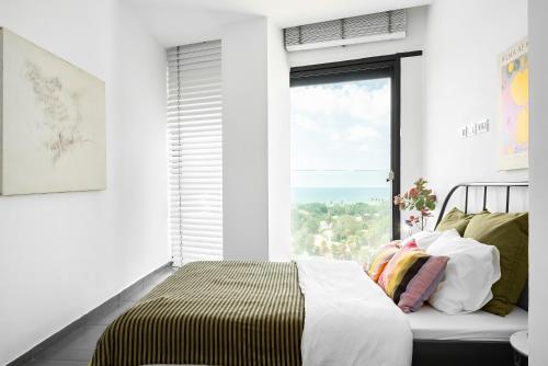 a bedroom with a bed and a large window at Boutique Duplex 3BR Florentin in Mashabbe Sade