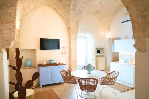 Una cocina y un comedor con mesa y sillas. en Dimora Zazzù - nel CUORE della MAGIA di OSTUNI, en Ostuni