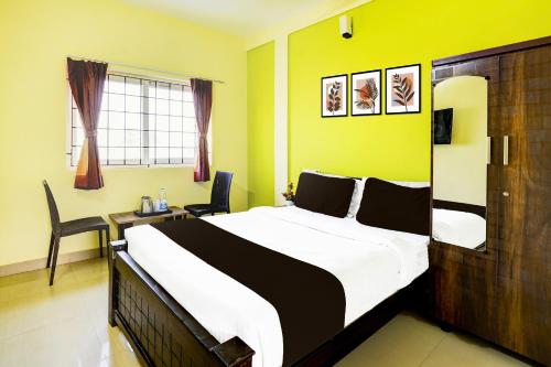 Un dormitorio con una cama grande y un escritorio. en Super Collection O Nibav Beach View, en Chennai