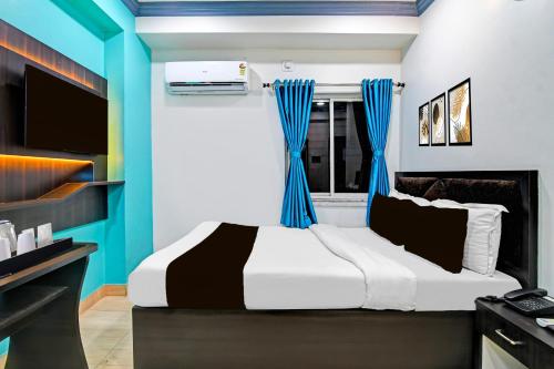 a bedroom with a large bed with blue accents at Super Collection O Kolkata Near Dumdum Airport in kolkata