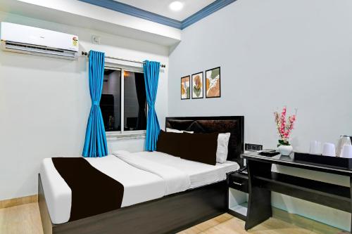 a bedroom with a bed and a piano at Super Collection O Kolkata Near Dumdum Airport in kolkata