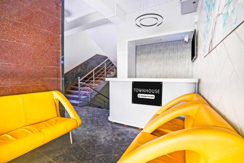 a yellow bench in a room with a staircase at Super Collection O Singasandra Hosa Road in Bengaluru