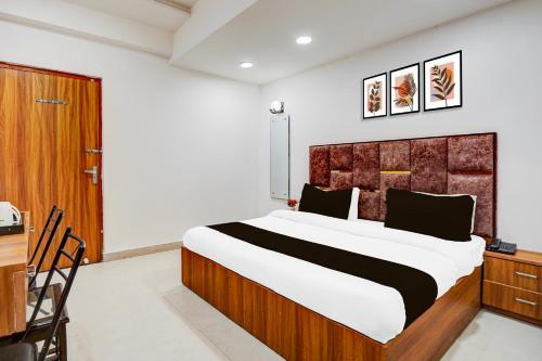 ein Schlafzimmer mit einem großen Bett mit einem hölzernen Kopfteil in der Unterkunft Hotel O Kargil Complex Formerly Saarthi Inn in Agra