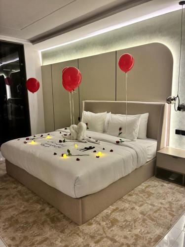 a large bed with red balloons and candles on it at فندق لوكسري سويتس- Luxury Suites Hotel in Taif