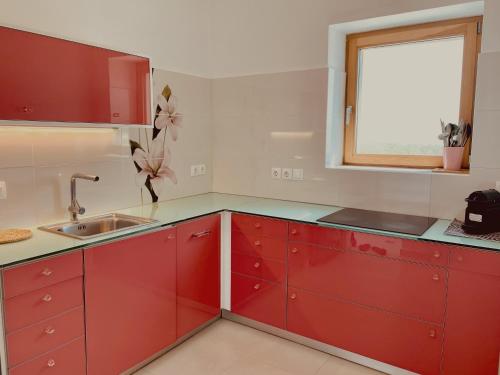 a red kitchen with a sink and a window at Spiti su in Paros - Naousa con vista in Kampos Paros