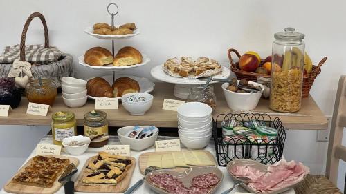 a table with many different types of bread and pastries at B&B dalla Eli in Bosco Chiesanuova