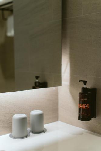 a bathroom with a mirror and a soap dispenser at PAAK Hotel Suvarnabhumi in Lat Krabang
