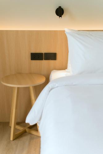 a bedroom with a bed and a table at PAAK Hotel Suvarnabhumi in Lat Krabang