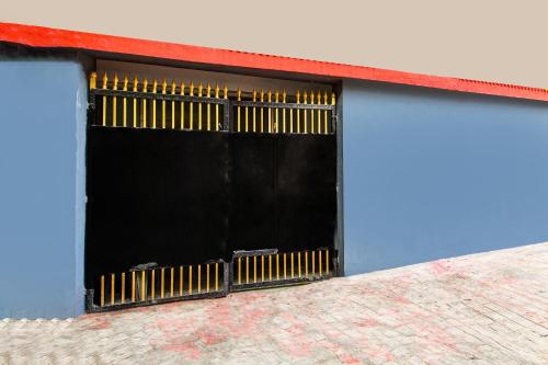 a building with a black and yellow garage door at Super Hotel O Alipore Near Chetla Formerly Alipore Guest House in Kolkata