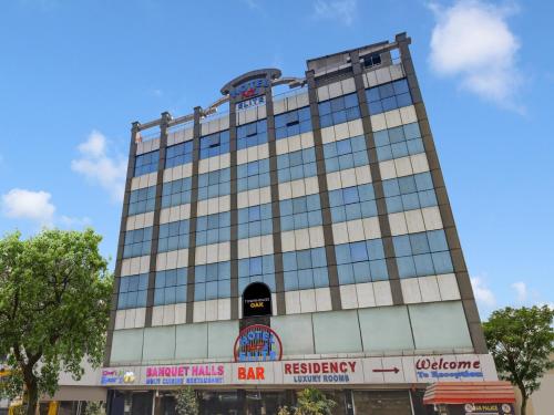 a tall building with glass windows on a street at Super Townhouse Oak LB Nagar Ramoji in Hyderabad