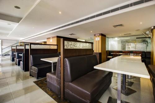 a dining room with tables and leather chairs at Super Townhouse Oak LB Nagar Ramoji in Hyderabad
