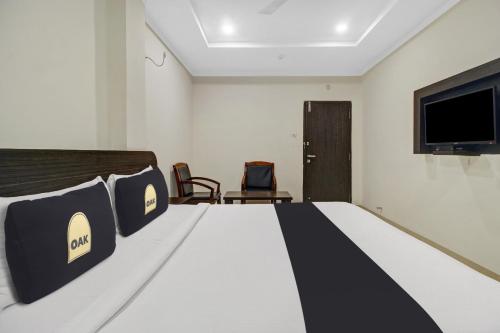 a bedroom with a bed and a flat screen tv at Super Townhouse Oak LB Nagar Ramoji in Hyderabad