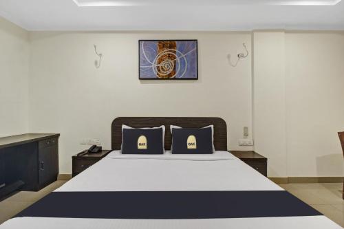 a bedroom with a bed with black and white sheets at Super Townhouse Oak LB Nagar Ramoji in Hyderabad
