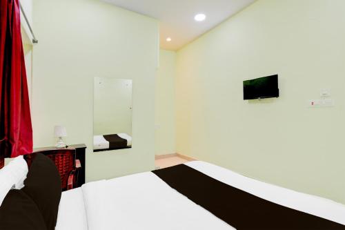 a white room with a bed and a television at Super Hotel O Moula Ali Neredmet in Hyderabad