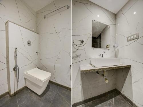 a white bathroom with a toilet and a sink at Super Townhouse Madgaon in Goa