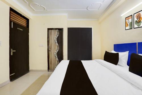 a bedroom with a bed with a black door at Super Hotel O Sheetla Colony in Gurgaon