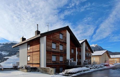 a large wooden building with snow on the ground at Tgesa La Niva 1 in Savognin