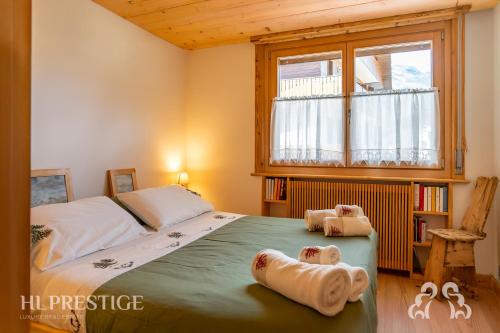 a bedroom with a bed with two towels on it at Dimora del Corso Cortina in Cortina dʼAmpezzo