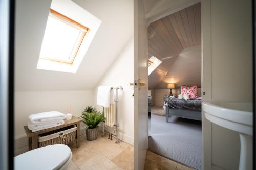 bagno con servizi igienici, lavandino e letto di Buzzard Cottage nestled in a hillside farm a Stirling