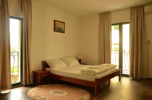 Un dormitorio con una cama y dos grandes ventanales. en Lero Apartments, en Budva