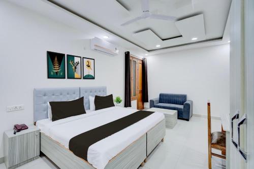 a bedroom with a large bed and a blue chair at Super Townhouse Sector 135 Noida in Noida