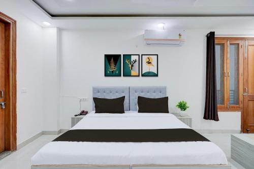 a white bedroom with a large white bed in it at Super Townhouse Sector 135 Noida in Noida