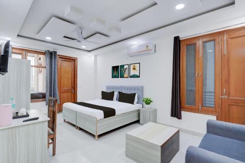 a bedroom with a bed and a tv and a couch at Super Townhouse Sector 135 Noida in Noida
