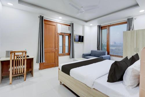 a bedroom with a bed and a desk and window at Super Townhouse Sector 135 Noida in Noida