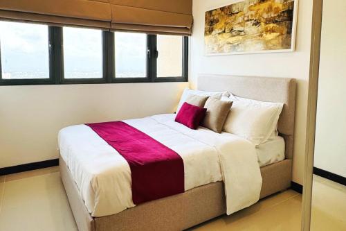 a bedroom with a bed with a purple pillow on it at YAKA Trizen Luxury Apartments - 53rd and 51st Floor with Stunning Views in Colombo