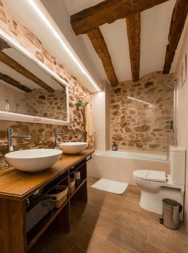 a bathroom with two sinks and a tub and a toilet at Casa Masovera in Linares de Mora