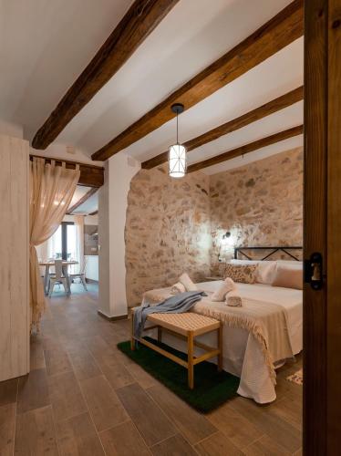 a bedroom with a bed and a stone wall at Casa Masovera in Linares de Mora