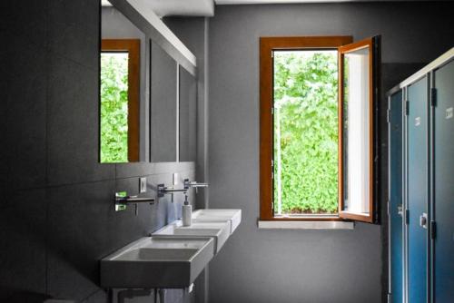 a bathroom with three sinks and two windows at Agri Campeggio La Passeggiata in Goito