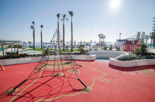 a net on a red floor with palm trees at Sea Senses by Mar Holidays in Torrevieja