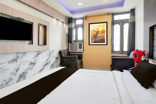 a hotel room with a bed and a flat screen tv at Super Collection O Kanpur Central Railway Junction Formerly Maharaja Palace in Kānpur