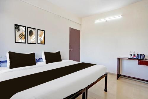 a bedroom with a large bed in a room at Super Hotel O Rane Nagar formerly Shree Mangal Complex in Nashik