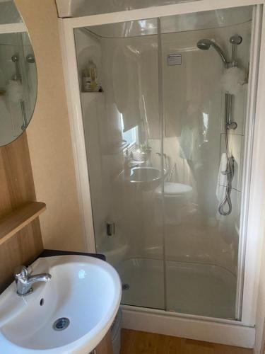 a bathroom with a glass shower and a sink at Turnberry holiday park in Turnberry
