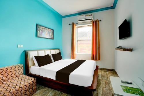 a bedroom with blue walls and a bed and a chair at Super Collection O Salasar Balaji Temple Formerly Keshav Mahal in Sālāsar