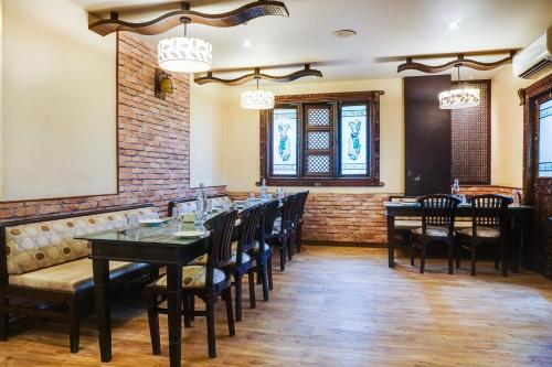 a dining room with tables and chairs and a brick wall at Super Townhouse Oak Prabhat Road in Pune