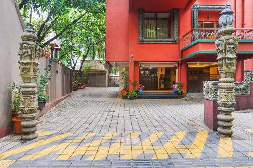 a red building with a brick street in front at Super Townhouse Oak Prabhat Road in Pune