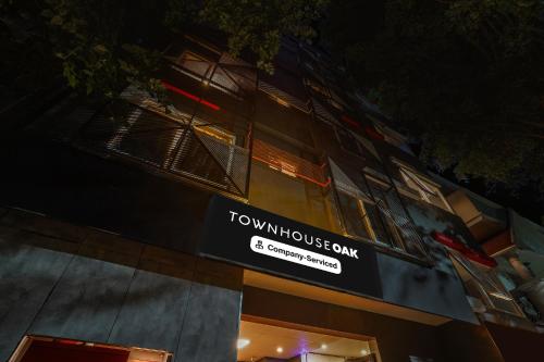 a tall building with a sign on the side of it at Super Townhouse Oak Indiranagar in Bengaluru