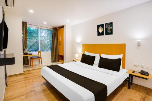 a bedroom with a large bed in a room at Super Townhouse Oak Indiranagar in Bengaluru