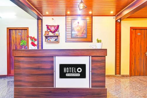 a hotel lobby with a sign on the wall at Super Hotel O Srigandhakavalu formerly Chamundeshwari Lodging in Bengaluru