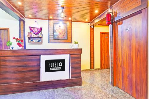 a lobby with a tv on a wall at Super Hotel O Srigandhakavalu formerly Chamundeshwari Lodging in Bengaluru